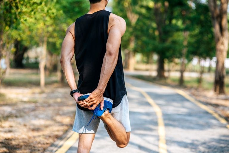 Persona estirando al aire libre tras entrenar.