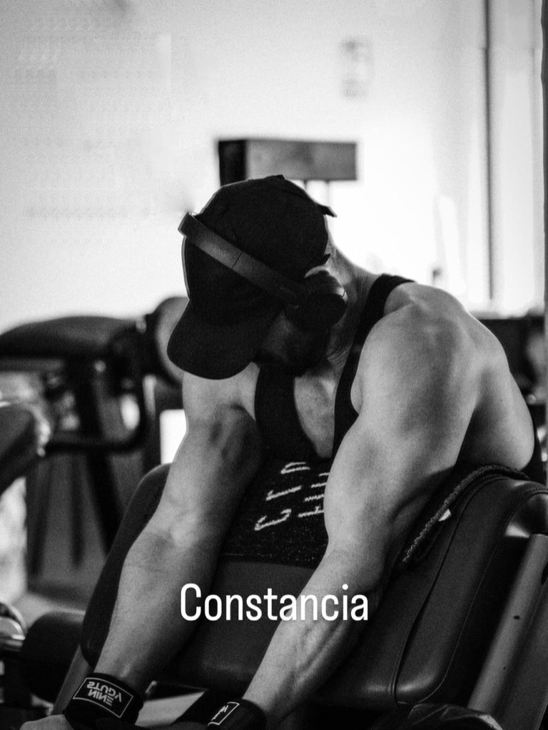 Alejandro Albornoz sentado en la máquina, encorvado, recuperando entre series. Sobre la imagen, la palabra Constancia.